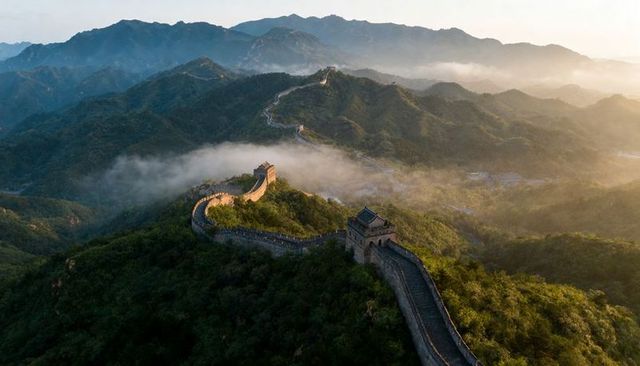 Great wall of china winding along misty mountain ridges at sunrise with ancient watchtowers