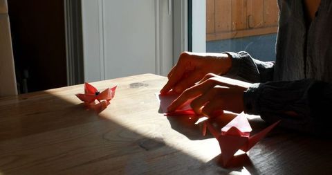 Woman Crafting Origami in Sunlit Room - Download Free Stock Images Pikwizard.com