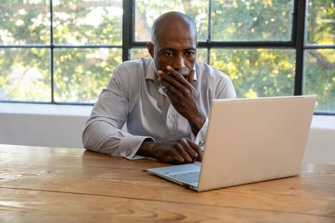 Focused african american professional using laptop in modern office