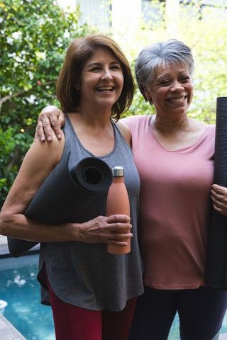 Senior Women Holding Yoga Mats Enjoying Outdoor Leisure by Pool