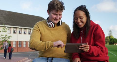 Cheerful Teenagers Using Tablet Outdoors on School Grounds