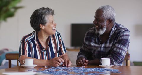 Senior african american couple enjoying jigsaw puzzle at home