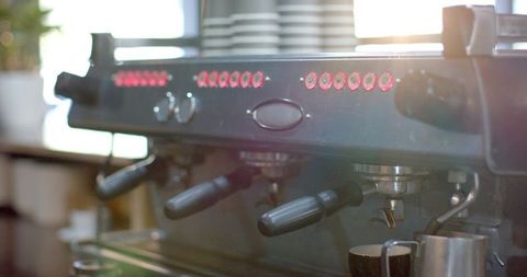 Commercial espresso machine with portafilters and warm sunlight