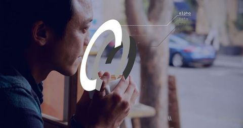 Man holding mug, gazing out cafe window with digital overlay