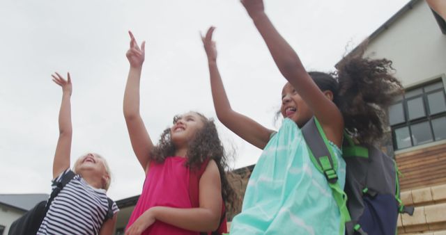 Joyful children playing outdoors with raised hands - Download Free Stock Images Pikwizard.com