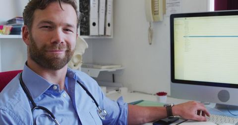 Smiling Male Doctor Using Desktop in Retirement Home Office - Download Free Stock Images Pikwizard.com