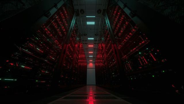 Moody data center aisle with converging perspective and red teal server rack lighting