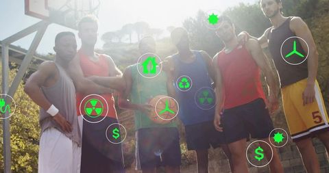 Six young men posing with basketball on backlit outdoor court showing teamwork energy
