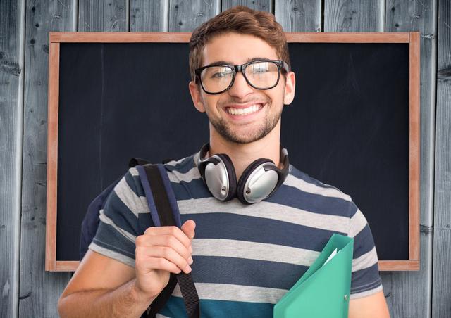 Young student standing confidently with a backpack and a file in front of a blackboard against a wooden plank background. Perfect for educational websites, academic promotion materials, school brochures, back-to-school campaigns, and learning-related content.