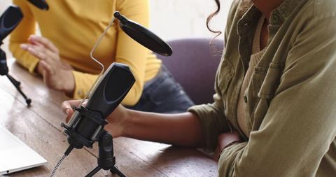 Women podcasters recording in home studio with microphones