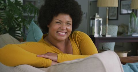 Happy Plus-Size African American Woman Relaxing on Sofa at Home