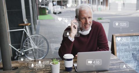 Senior Man Using Laptop with Social Media Notifications