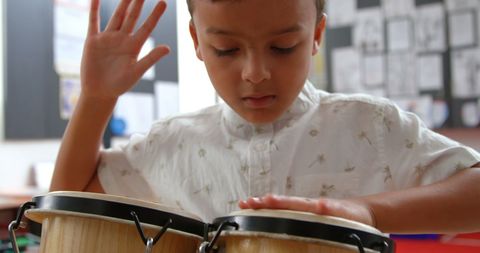 Attentive Boy Playing Bongos in Classroom Promoting Music Learning - Download Free Stock Images Pikwizard.com