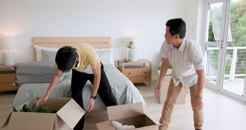 Father and son packing boxes for moving day