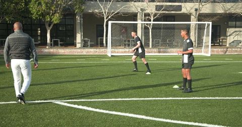 Soccer team practicing passing drills on sunny field