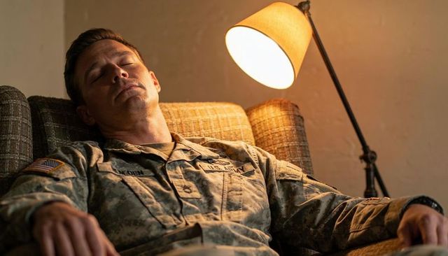 Us army soldier sleeping on armchair under warm lamp light, cozy domestic rest