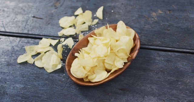 Close up view of potato chips in a bowl with copy space on wooden surface. food and snack concept
