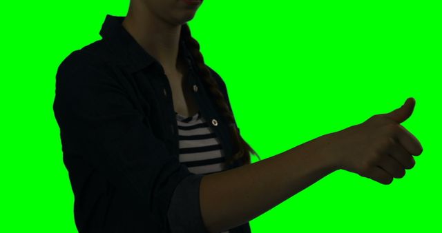 Mid section of woman using digital screen against green screen 