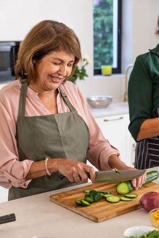 Mature Hispanic Woman Preparing Healthy Meal in Modern Kitchen