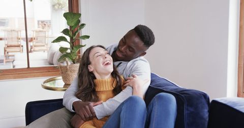 Joyful Couple Embracing on Comfortable Sofa at Home
