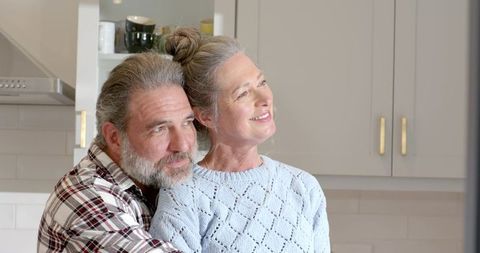 Senior Couple Embracing in Modern Kitchen Celebrating Happy Moments