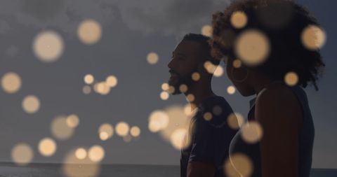 Romantic Couple Enjoying Sunset by Beach with Bokeh Effect