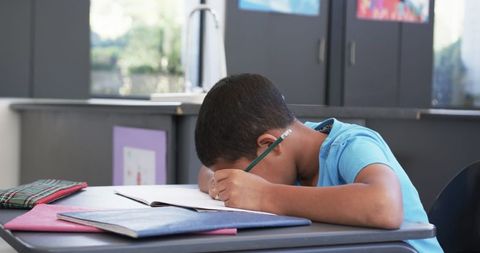 Focused Boy Writing in Classroom with Chemistry Decor