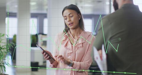 Diverse business team analyzing data on smart devices in office