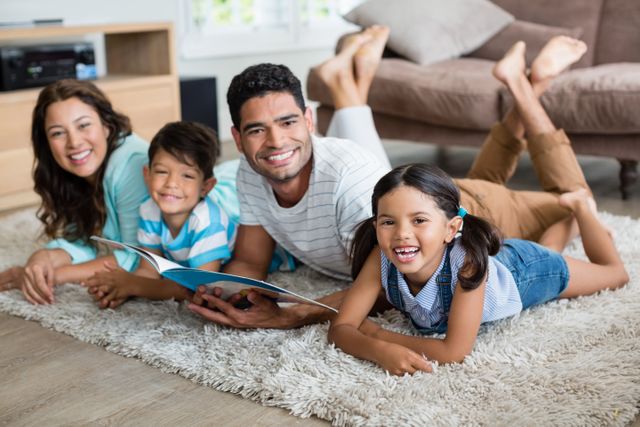 Family enjoying quality time together while reading a book on a cozy rug in the living room. Perfect for illustrating concepts of family bonding, parenting, childhood education, and leisure activities at home. Ideal for use in advertisements, family-oriented articles, and educational materials.