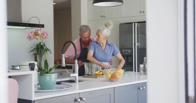 Caucasian senior couple wearing aprons cooking together in kitchen - Download Free Stock Photos Pikwizard.com