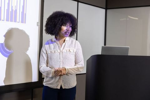 Professional woman presenting charts at business conference