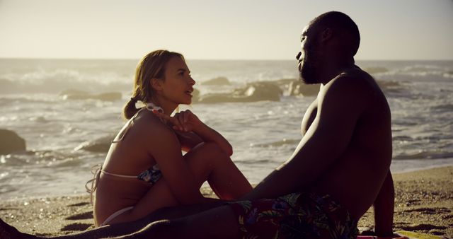Interracial Couple Relaxing on Sandy Beach at Sunset - Download Free Stock Images Pikwizard.com