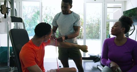 Personal Trainer Guiding Couple in Home Gym Workout Session