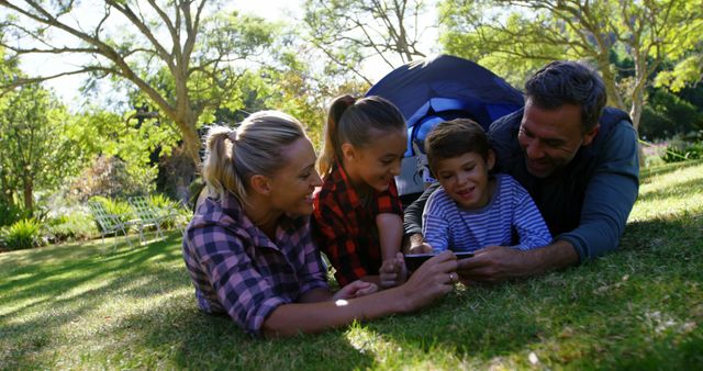 A family shares a joyful moment of bonding over technology in nature. - Download Free Stock Photos Pikwizard.com