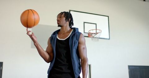Athletic African American Man Spinning Basketball Indoors