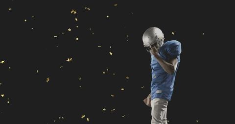 Football player in blue jersey holding ball amid gold stars on dark background