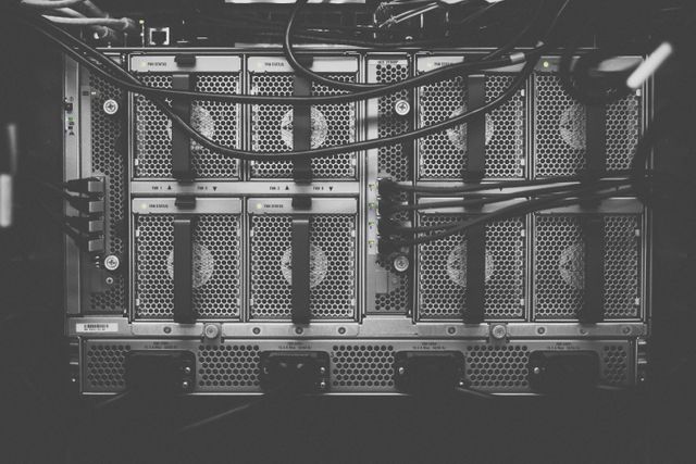 Network server racks with interconnected cables in modern data center. Useful for representing information technology, server management, cloud computing, or IT infrastructure. Applicable for technology or business-related content showcasing advanced data management.