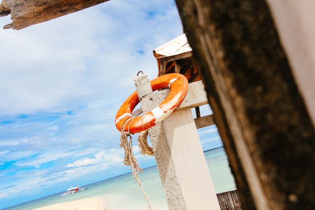 Life Ring on Tropical Beach with Clear Blue Sky and Distant Boat - Download Free Stock Images Pikwizard.com