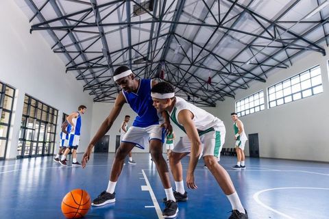 Intense Basketball Match in Gym with Defensive Play
