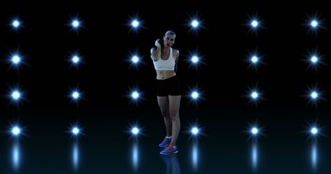 Athletic woman prepares for discus throw amidst vibrant lights