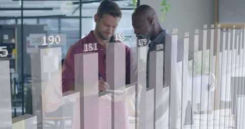 Colleagues Reviewing Data and Taking Notes with Bar Chart Overlay in Open Plan Office