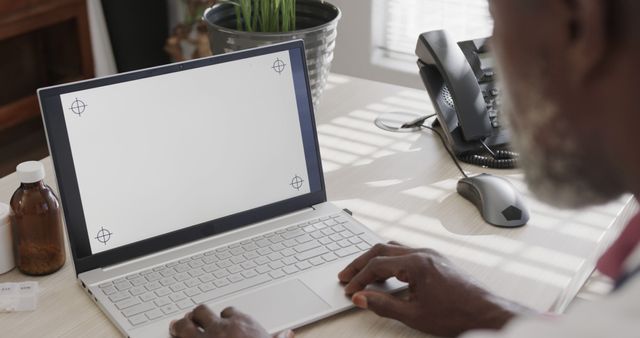 Man Working on White Laptop at Office Desk by Window - Download Free Stock Images Pikwizard.com