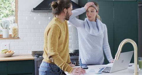 Couple Discussing Finances in Modern Kitchen Setting