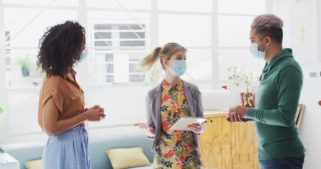 Young professional team discussing work in modern office wearing face masks - Download Free Stock Images Pikwizard.com