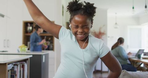 Joyful African American Girl Dancing with Earphones at Home