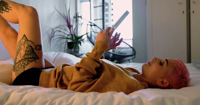 Young Woman Reading Digital Tablet in Bright Bedroom with Warm Light - Download Free Stock Images Pikwizard.com