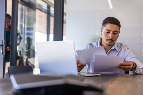 Professional Man Reviewing Documents in Modern Office