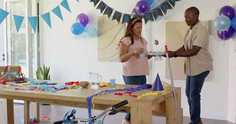 Couple preparing for birthday celebration with decorations