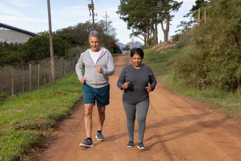 Senior Indian Couple Jogging on Rural Road Enjoying Fitness