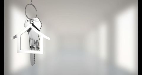 Hanging metal house-shaped keychain in minimalist interior